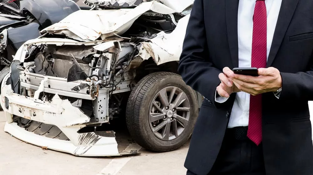An insurance representative inspecting vehicle damage after collision in Miami, FL